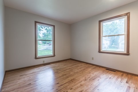 Davis bedroom with wood floor and two windows