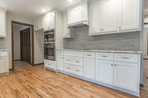 Shaker style cabinets, natural stone mist tile and wood flooring