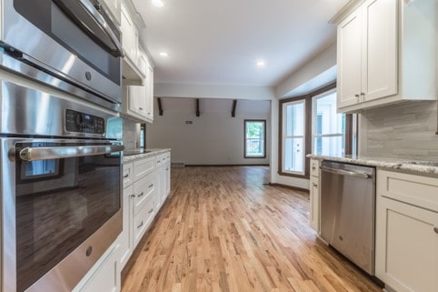 Galley kitchen with stainless appliances and dining area